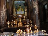 Kathmandu Patan 06 Mahabouddha Temple 04 Buddha Statue Flickering butter lamps and offerings frame a golden coloured statue of Buddha inside the Mahabouddha Temple in Patan.